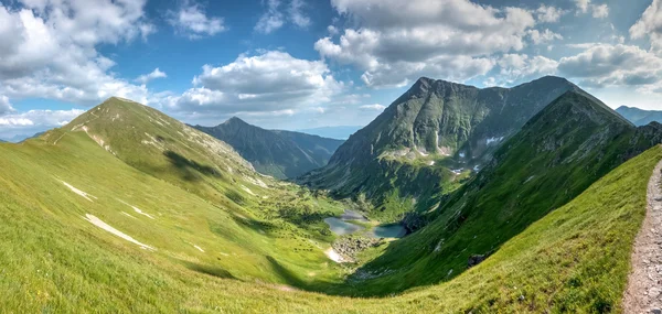 Maravilloso valle en las montañas de verano con los picos circundantes —  Fotos de Stock