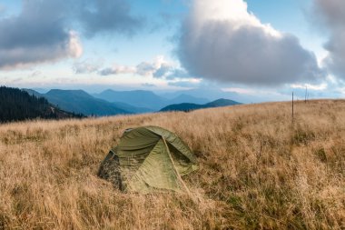 Dağ çayır sabah bulutlu gökyüzü altında çadır
