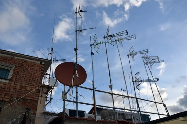 Una gran cantidad de antena en el techo de la casa pequeña foto — Foto de Stock