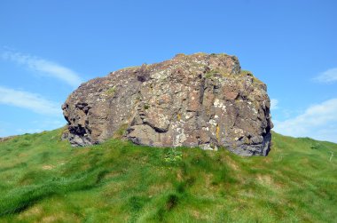 çim tepenin üst kısmında büyük eski kaya