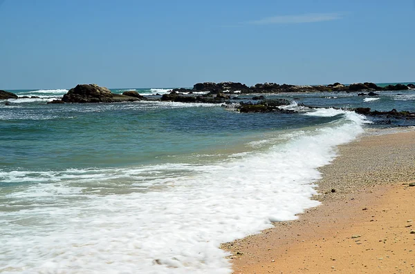 Тропічний пляж з камінням і блакитним небом біля моря — стокове фото