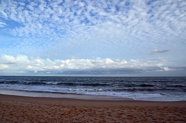 Spiaggia e cielo azzurro nuvoloso in riva al mare al tramonto — Foto Stock
