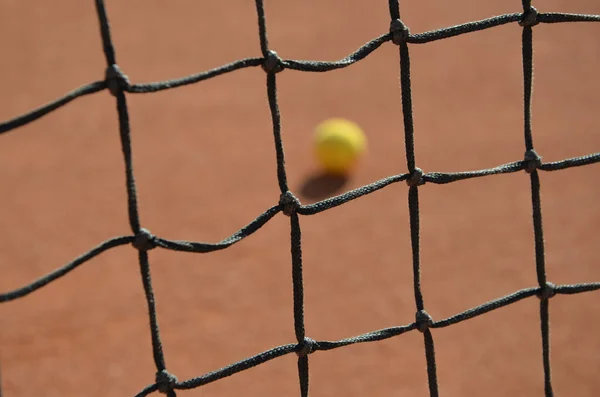 Tennisball verschwommenes Foto durch das Tennisnetz — Stockfoto