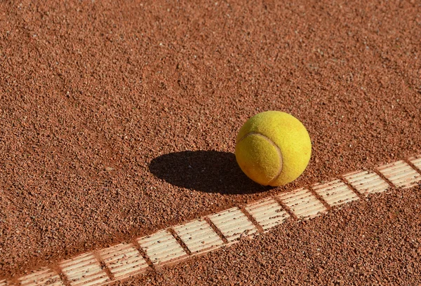 Μπάλα του τένις στο πεδίο πηλό τένις — Φωτογραφία Αρχείου