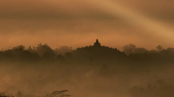 Dünyanın en büyük tapınağının silueti. Sabahları Borobudur Tapınağı yükselen güneşle aydınlanır.