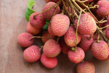 Tahta zemin üzerinde yaprak manzaralı taze Lychee tatlı meyvesi