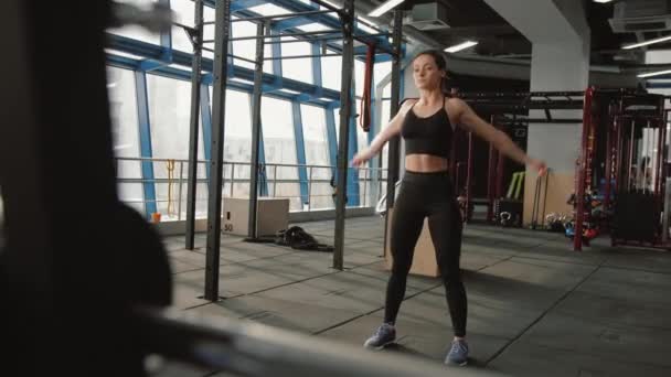 Young athletic woman doing warm up exercise, rotating hands in fitness center — Video