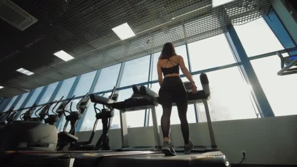 Fitness-Frau läuft im Fitnessstudio auf Laufband und macht Ausdauertraining — Stockvideo