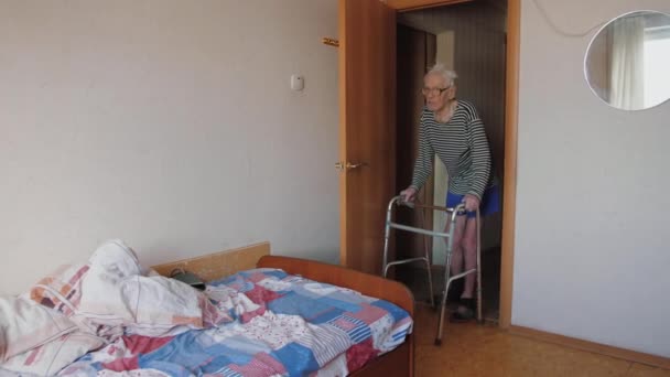 Idős öregember séta lassan segítségével Walker otthon, térd és láb probléma — Stock videók