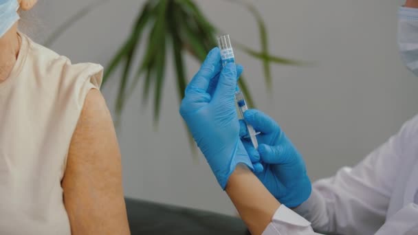 Lékařská sestra podávající injekci vakcíny u ramene staršího pacienta — Stock video