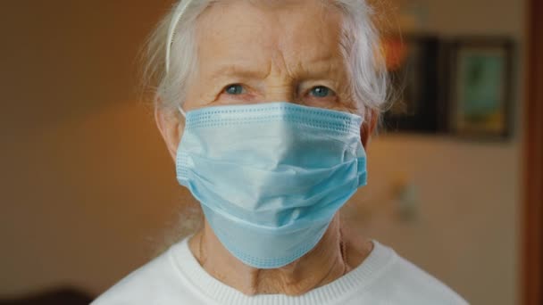 Retrato de anciana enmascarada mujer caucásica mirando a la cámara. — Vídeo de stock