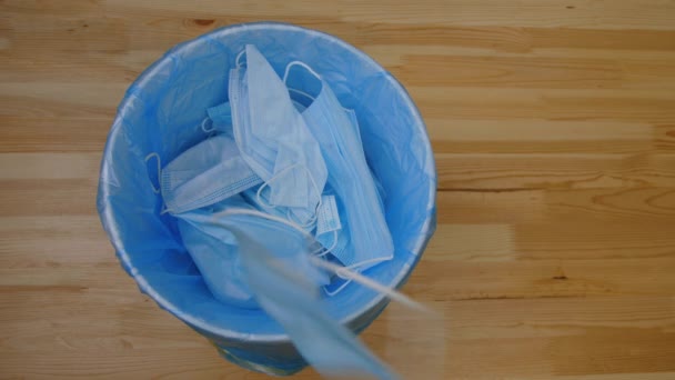 Het gooien van gebruikte medische maskers in afval, volgorde van schot. Afgedankte chirurgische maskers — Stockvideo