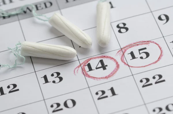 Tampons on a menstruation calendar — Stock Photo, Image