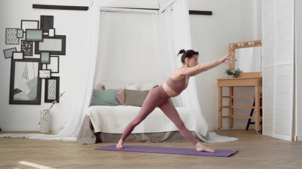 Caucasian woman in sportswear performs yoga asanas bhujangasana in room — Stock Video