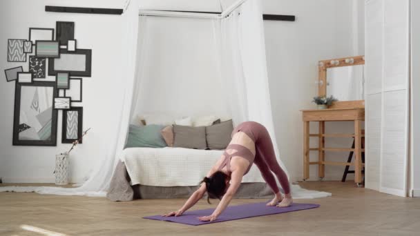 Kaukasische vrouw in sportkleding voert yoga asanas eka pada rajakapotasana — Stockvideo