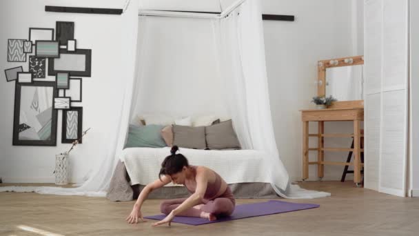 Белая женщина в спортивной одежде выполняет йогу асанас лотос, мудра — стоковое видео