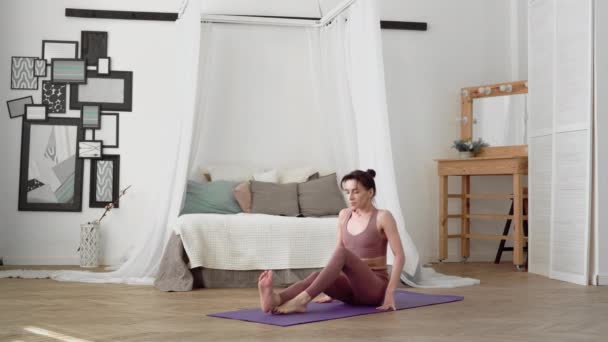 Kaukasierin in Sportbekleidung führt Yoga-Asanas Ugrasana durch — Stockvideo