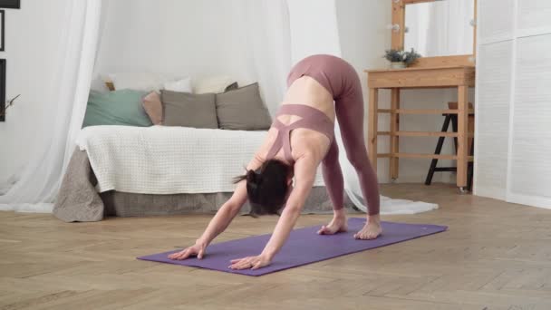 Kaukasisk kvinna i sportkläder utför yoga bakasana på händerna — Stockvideo