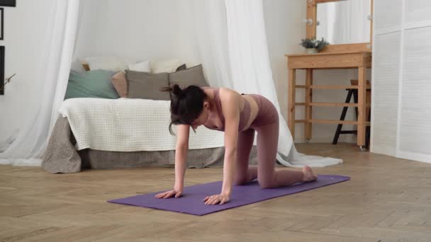 Mujer caucásica en ropa deportiva realiza yoga asanas aguja pose — Vídeos de Stock