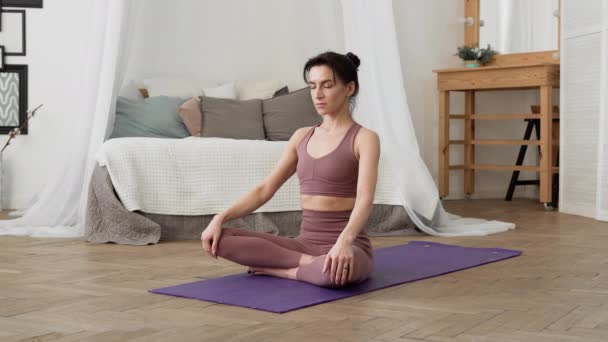 Mujer caucásica en ropa deportiva realiza yoga relax asanas pranayama — Vídeo de stock