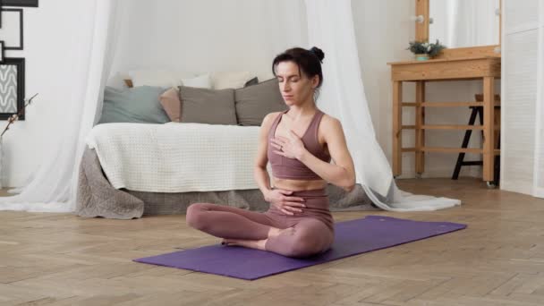 Caucasian woman in sportswear performs yoga relax asanas pranayama — Stock Video