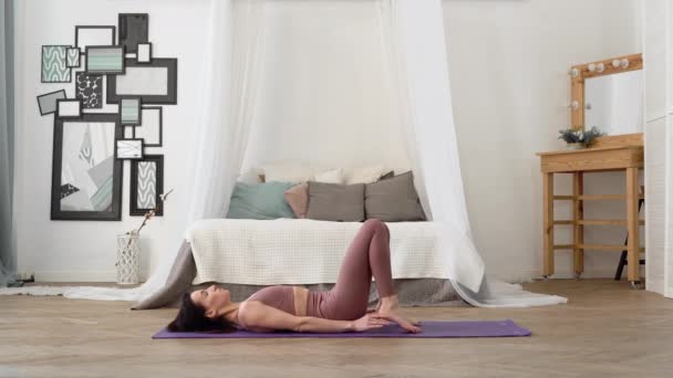Mujer caucásica en ropa deportiva realiza yoga asanas rueda pose — Vídeo de stock