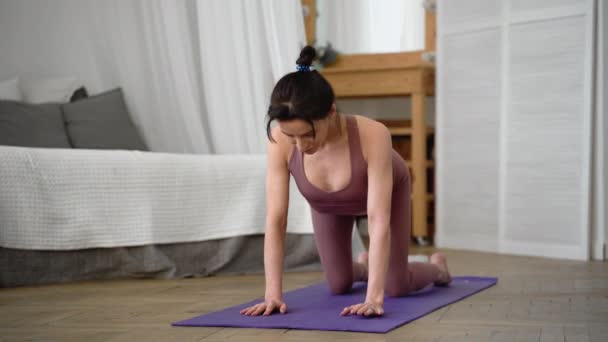 Donna caucasica in abbigliamento sportivo esegue yoga parshva balasana, posa ago — Video Stock