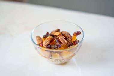 Yulaf ezmesi, kurutulmuş meyve ve fındıklı müsli cam bir kasede kesilmiş.