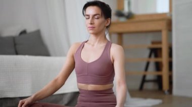 Beyaz kadın spor kıyafetleri içinde yoga yapıyor, Asanas Pranayama 'yı rahatlatıyor.
