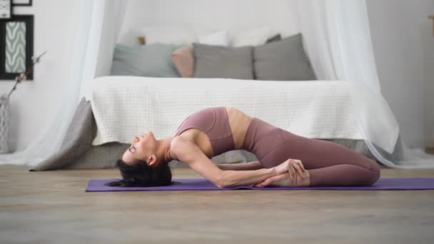 Kaukasiska kvinna i sportkläder utför yoga hjälte pose supta virasana — Stockvideo