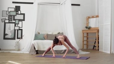 Beyaz kadın spor giyim sektöründe yoga yapıyor. Uzun bacaklı forvet.