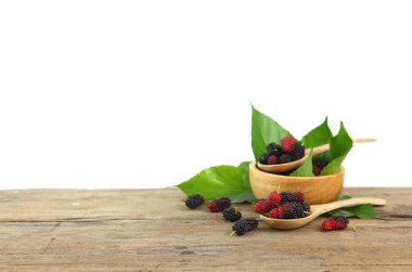 Group of mulberries on wooden table isolated on white background