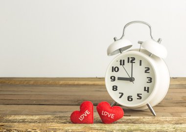 Retro saat ve kalpleri ahşap ve beyaz arka plan üzerinde