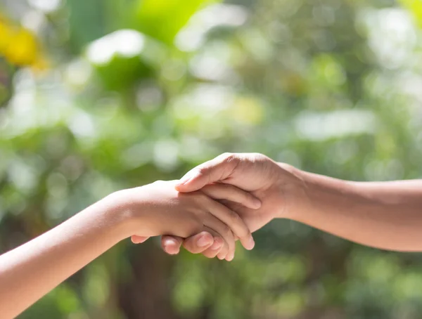 Helping hands against nature background — Stock Photo, Image