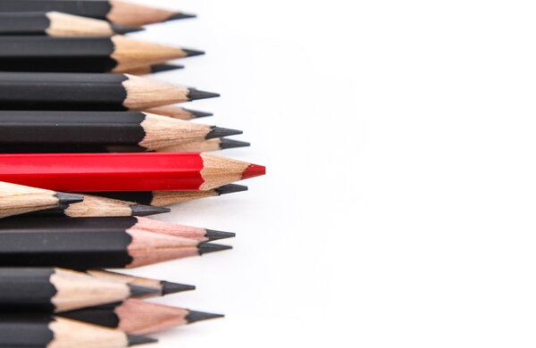 A red pencil against black pencil