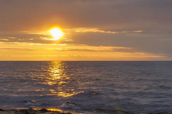 The sun sets over the horizon in the baltic sea