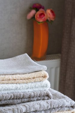 Beyaz bir masanın üzerinde bir yığın terry duş havlusu..