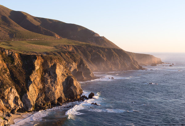 Rocky cliff on pacific ocean ocean shore in northern California next to Big Sur state park with waves and rocks