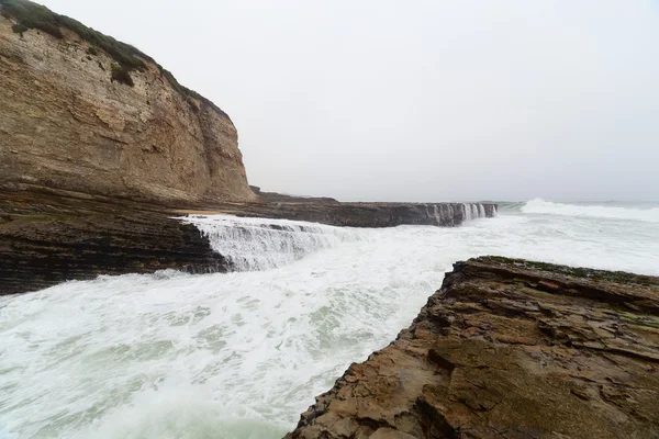 Ondas oceânicas quebrando em rochas costeiras — Fotografia de Stock