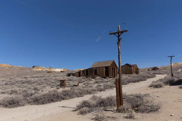 Lignes électriques sur fond de bâtiments en bois abandonnés — Photo