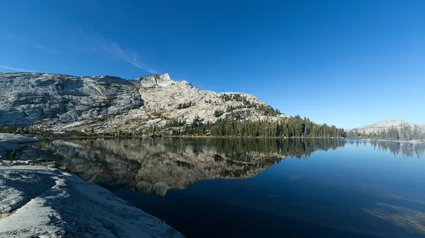 Montagne et pins réfléchissant sur le lac alpin — Photo