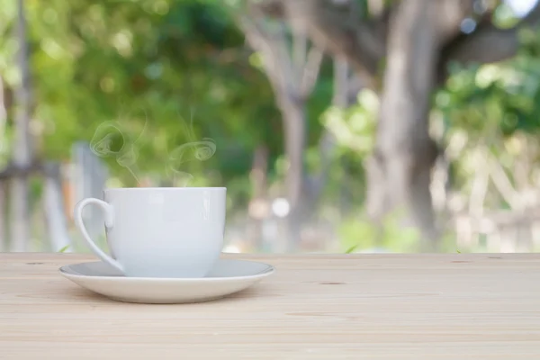 Cangkir kopi di atas meja dengan kecantikan latar belakang alam — Stok Foto