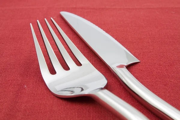 Garfo e faca na toalha de mesa vermelha — Fotografia de Stock