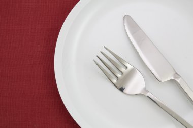 tabak, çatal ve bıçak üzerinde kırmızı masa örtüsü