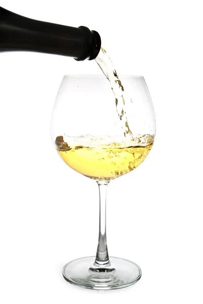 White wine pouring in a glass from a bottle — Stock Photo, Image