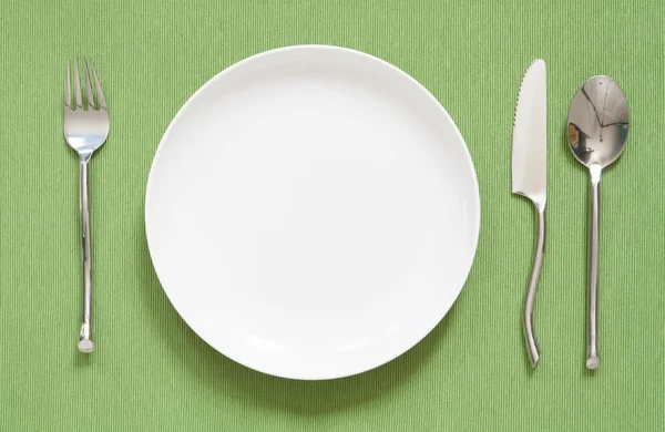 Lugar de la cena estableciendo un plato blanco con tenedor de plata y cuchara gr — Foto de Stock
