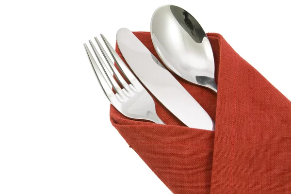 Forchetta cucchiaio e coltello su tovagliolo rosso isolato Fotografia Stock