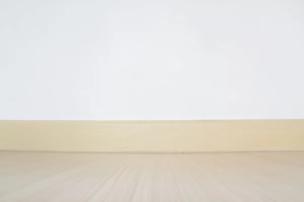 Copyspace background with an empty white wall with a hardwood wo — Stock Photo, Image