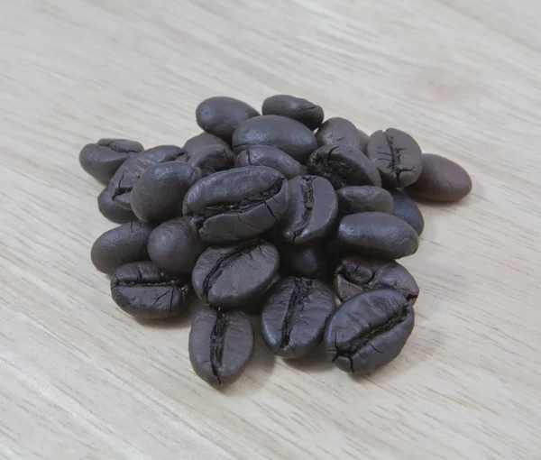 Coffee beans in closeup on wood — Stock Photo, Image