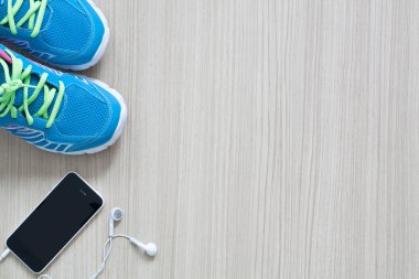 Düz ahşap ba spor spor ayakkabı earphones ve telefon shot yatıyordu